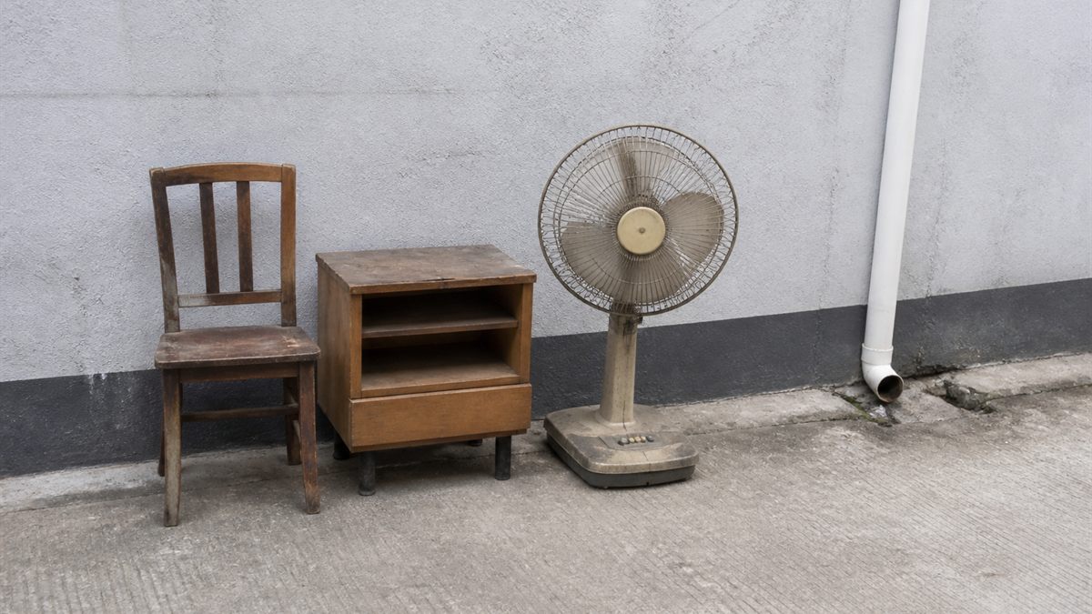 壁際にまとめた古い家具と扇風機