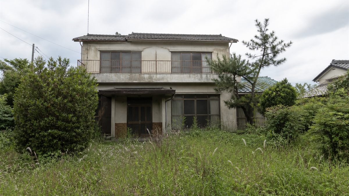 ほこりの積もった窓と荒れた前庭