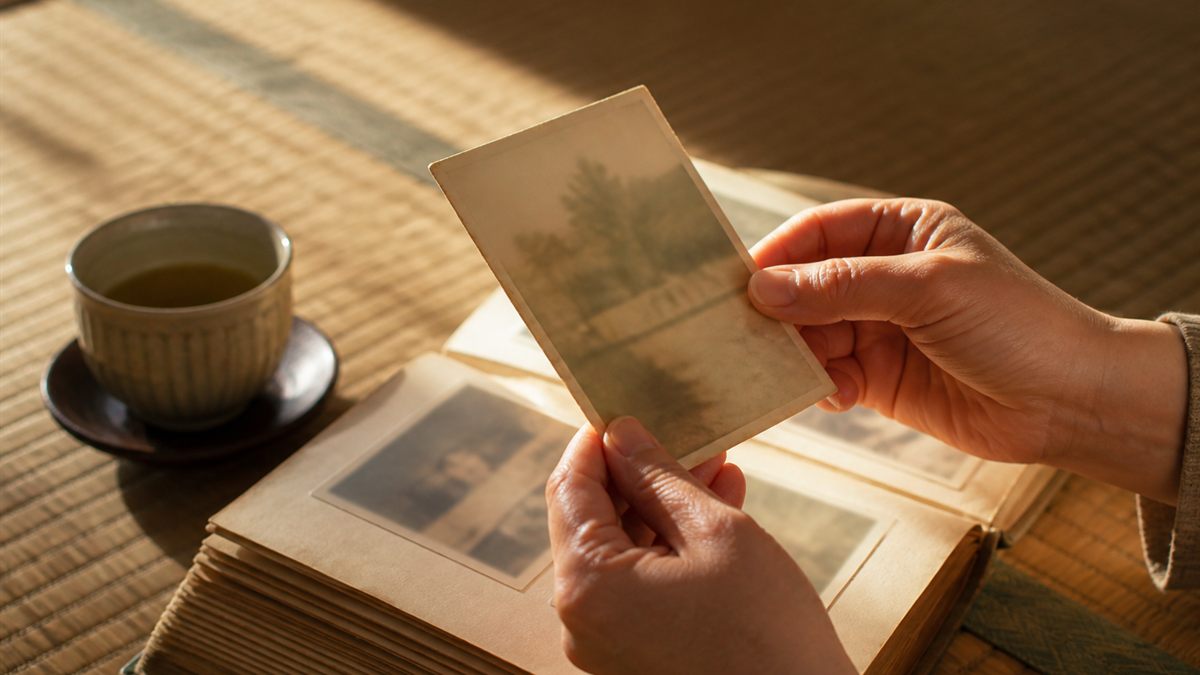 古い家族写真をそっと手に取る様子