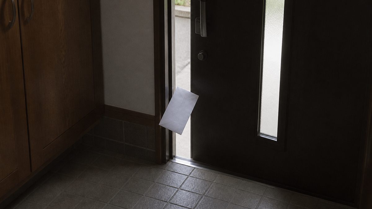 少し開いた玄関のすき間に差し込まれたチラシ