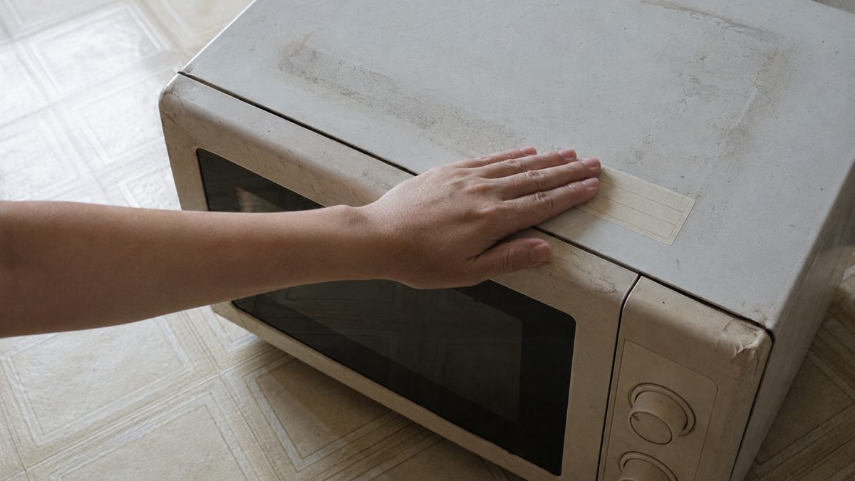 電子レンジの本体に手数料のシールを貼る手元