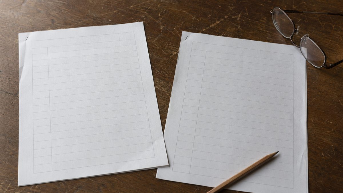 机に広げた土地の書類と読書用の眼鏡