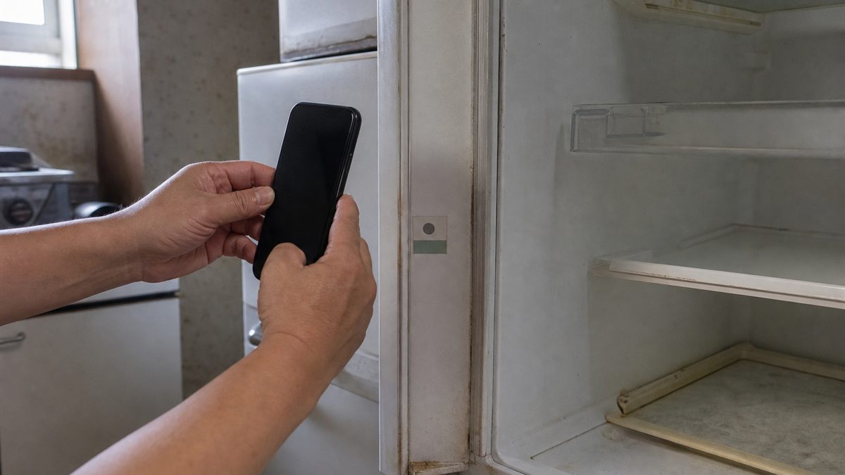 冷蔵庫の扉を開けて内側のシールを確かめる手元