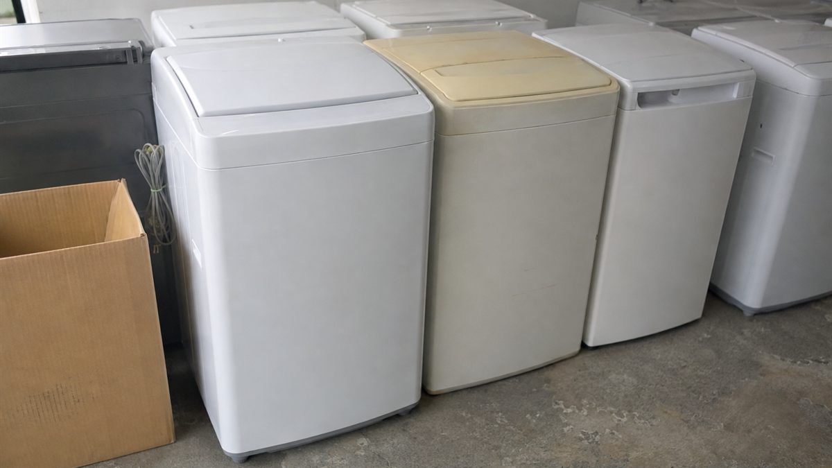 中古品店の店頭に並べられた使用済みの洗濯機
